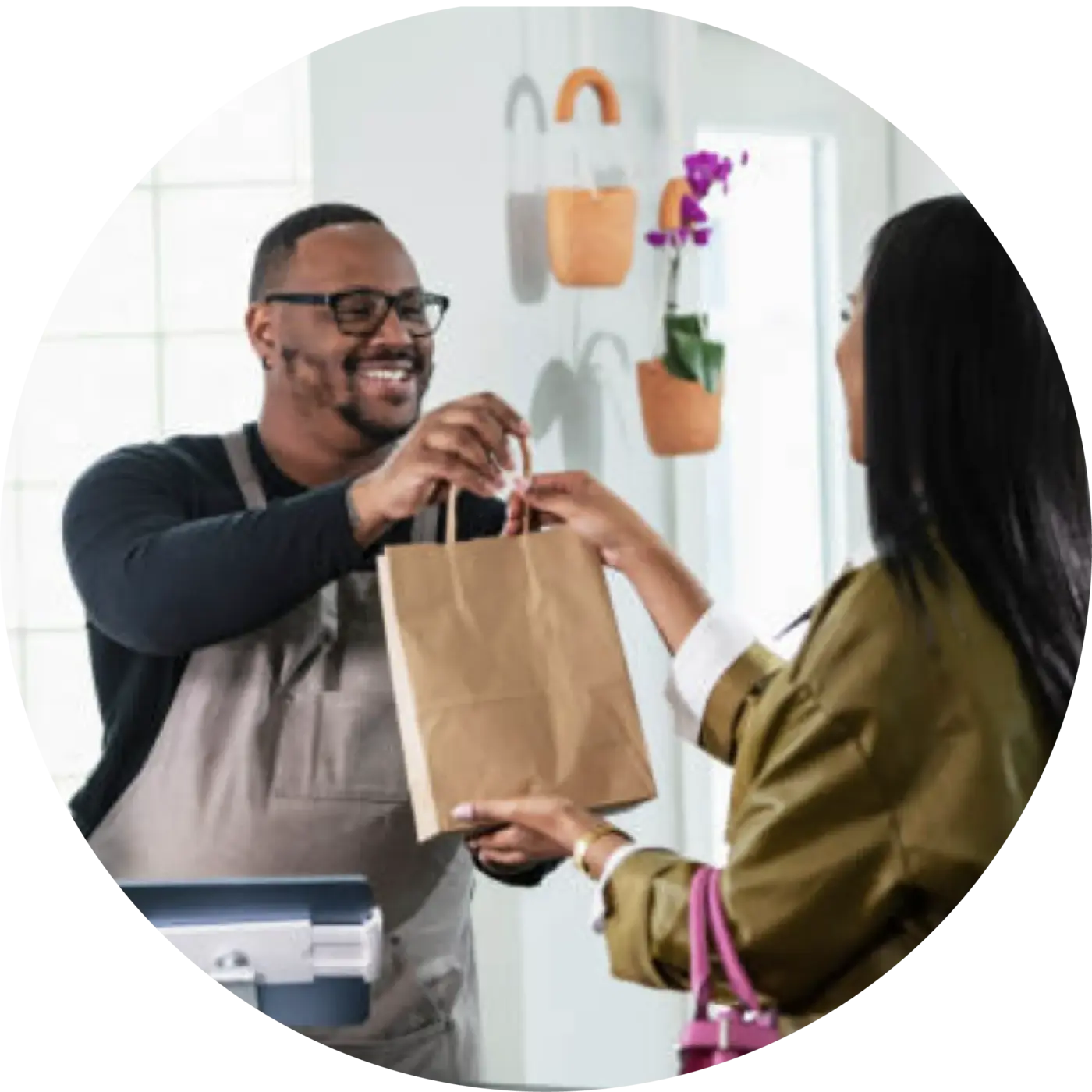 Shop owner handing a customer their purchase
